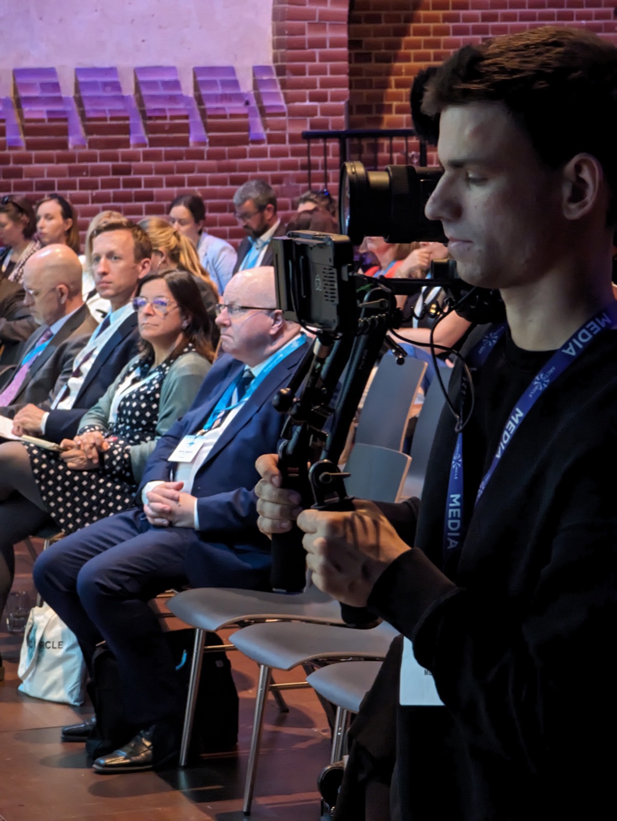 David filmt mit Gimbal mitten im Publikum einer Konferenz.